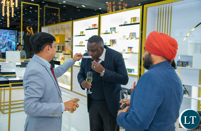 Swiss Arabian General Manager for global sales Mr. Pankaj Attery (left) giving a perfume sample to Permanent Secretary Robert Matakala (center) at the Swiss Arabian showroom grand opening at East Park mall.