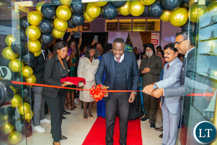 Permanent Secretary Robert Matakala cutting the ribbon signifying the opening of the Swiss Arabian showroom while the General Manager of global sales Mr. Pankaj Attery,(right) and Swiss Arabian Zambia CEO Mr. Ashutosh Shamar (far right) look on.